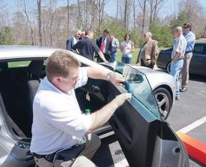 Keister Richardson, a marketing technical services representative with Eastman Chemical, installs window film Thursday on a vehicle at Patrick Henry Community College. (Bulletin photo by Mike Wray)